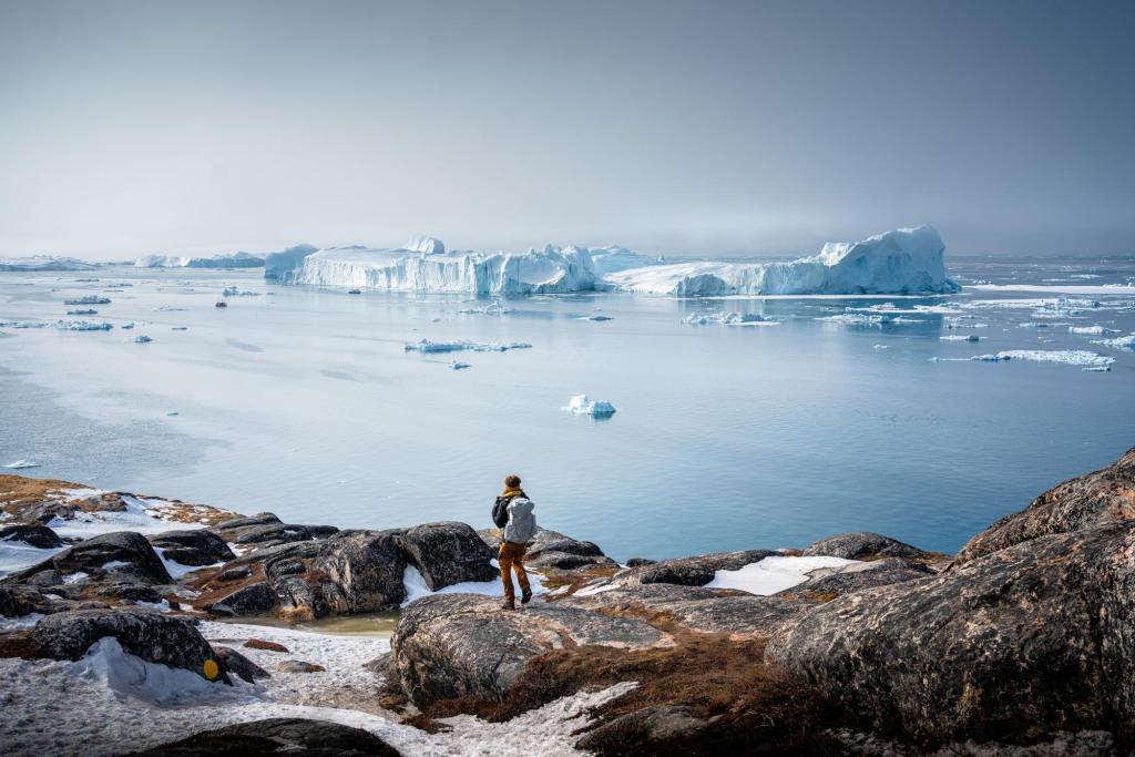 Ein Reisender bewundert die Aussicht auf den UNESCO Ilulissat Eisfjord