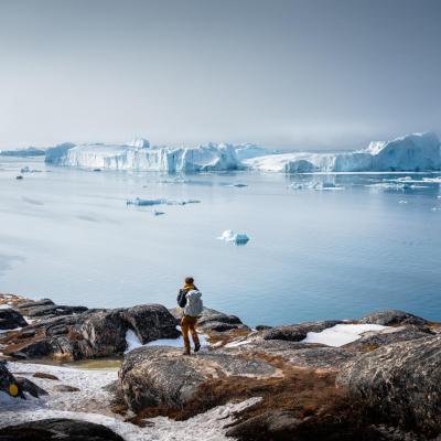 Ein Reisender bewundert die Aussicht auf den UNESCO Ilulissat Eisfjord