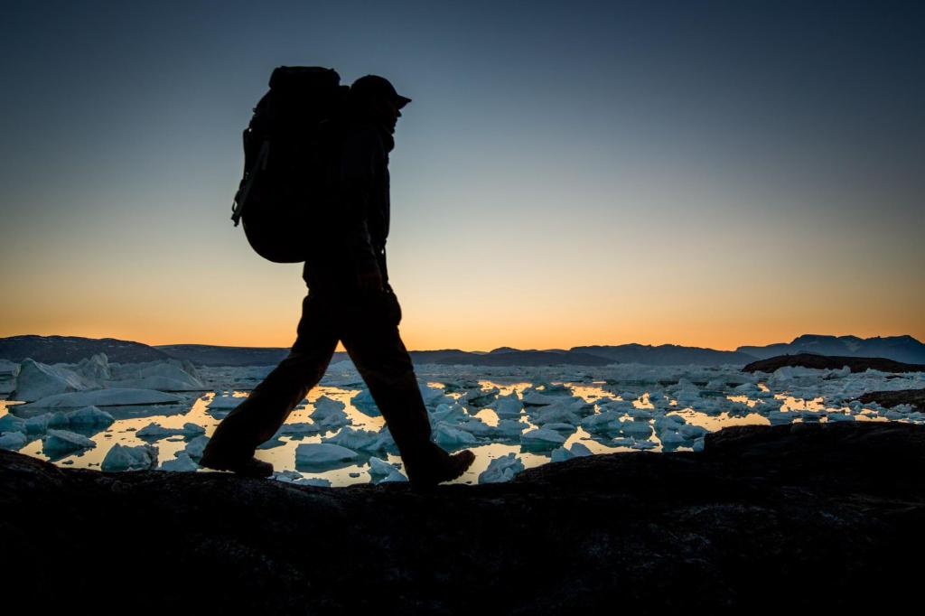 A hiker along the shores of Sermilik Ice Fjord near Tiniteqilaaq in East Greenland