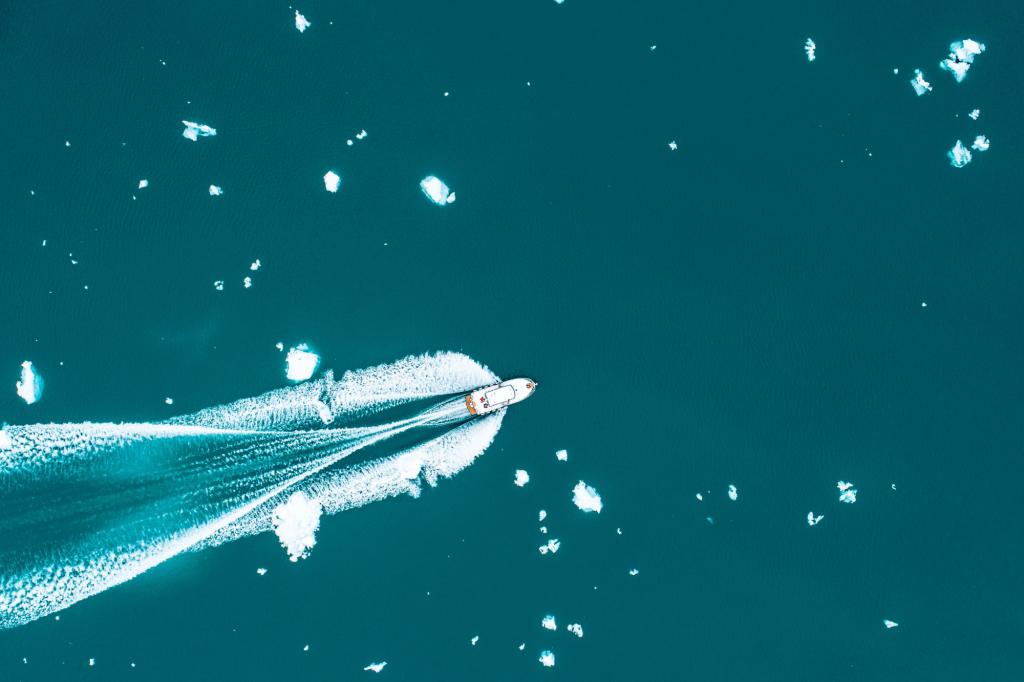 A passenger boat cutting through the iceberg-filled fjords of South Greenland